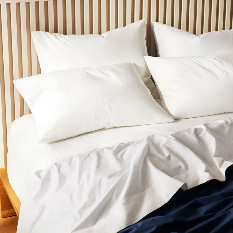 Best coastal bedding - Brooklinen Chill Percale sheets on a bed, highlighting their lightweight and airy nature.